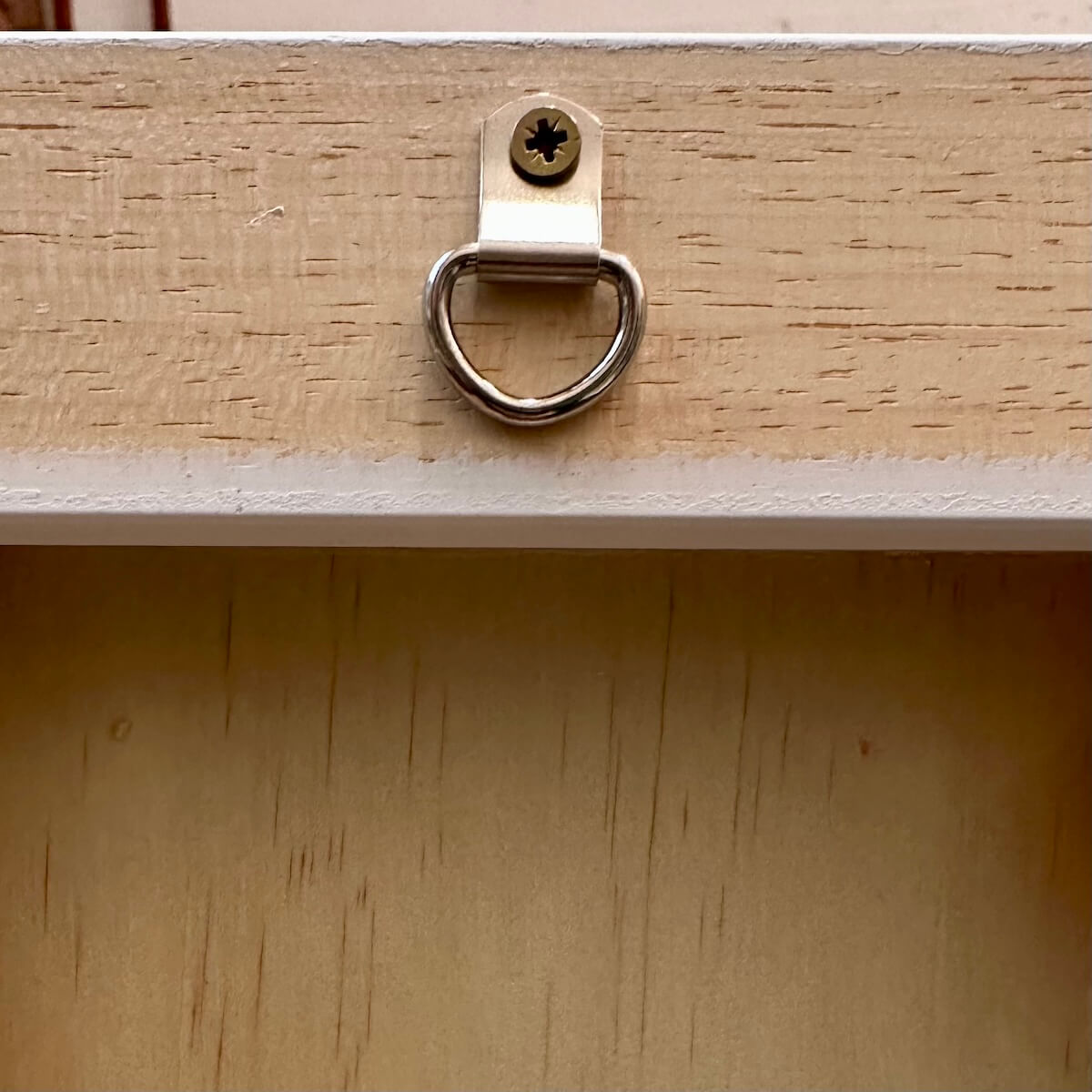 Metal hanger on back of a wooden frame