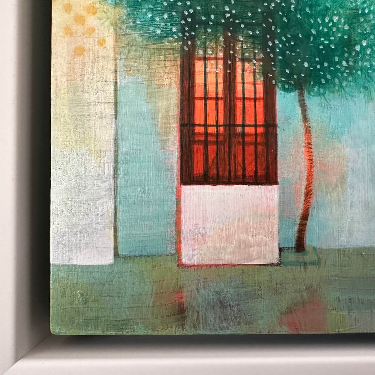 Detail of a Spanish painting facade with a red window and greenery