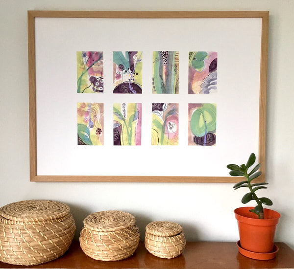 Profusion, abstract botanical art print by artist Teresa Flavin, flower forms, leaves, lily pad and stems in gold, mint green, pink and deep violet, shown in wood frame on wall.